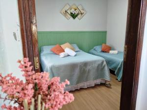 a reflection of a bedroom with two beds and a mirror at Chalé Elohim Campos do Jordão in Campos do Jordão