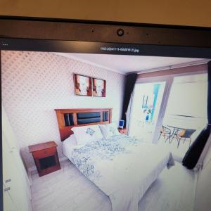 ein Schlafzimmer mit einem Bett und einem großen Fenster in der Unterkunft Departamento vista al Mar, Costa Lilenes Concon in Valparaíso