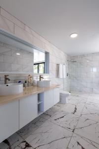 a white bathroom with two sinks and a toilet at Perla 8- Exclusiva Moderna Villa 4 Habitaciones y Piscina in Sosúa +26 photos