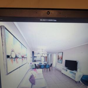 ein Wohnzimmer mit einem Flachbildfernseher an der Wand in der Unterkunft Departamento vista al Mar, Costa Lilenes Concon in Valparaíso
