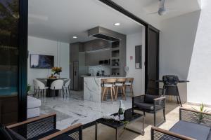 a kitchen and living room with a table and chairs at Perla 8- Exclusiva Moderna Villa 4 Habitaciones y Piscina in Sosúa