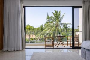 a bedroom with a view of a palm tree at Perla 8- Exclusiva Moderna Villa 4 Habitaciones y Piscina in Sosúa