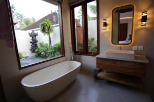 Un baño con una bañera grande y un lavabo. en Denaya Villa, en Ubud 27 fotos más