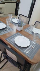 a wooden table with plates and utensils on it at Apto 4 andar com vista incrível para piscina in Lucas do Rio Verde