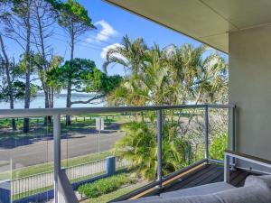 a balcony with a view of a street and palm trees at Welcome to Bay Views on Esplanade in Tin Can Bay +13 photos