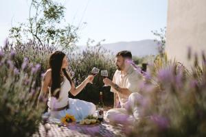 a man and woman sitting on a picnic with wine glasses at Equ Hotel Boutique in El Porvenir