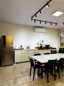 een grote keuken met een tafel en een koelkast bij Mangueirosa Hostel in Belém