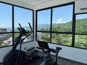 a room with a gym with views of the mountains at Modern 2BR Ocean view - Walk to Beach and Downtown in Puerto Vallarta