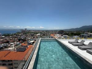a swimming pool on the roof of a building at Modern 2BR Ocean view - Walk to Beach and Downtown in Puerto Vallarta