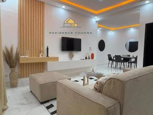un soggiorno con televisione e tavolo di luxury a Abidjan