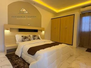 una camera con un grande letto con un cartello sul muro di luxury a Abidjan