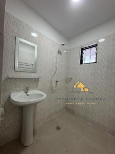 un bagno con lavandino, doccia e specchio di luxury a Abidjan Altre 16 foto