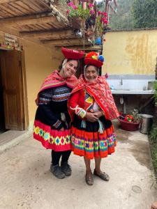 two women in traditional dress posing for a picture at Munay Kausay in Urubamba