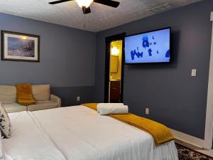 Un dormitorio con una cama y un televisor de pantalla plana. en Spacious, Quiet, Near Zoo, Stadium & Family Spots, en Atlanta