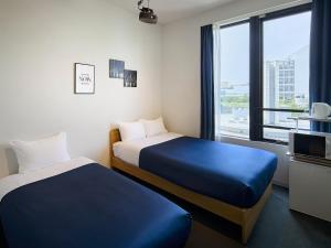 Giường trong phòng chung tại Theatel Haneda Ⅱ