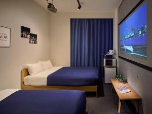 Giường trong phòng chung tại Theatel Haneda Ⅱ