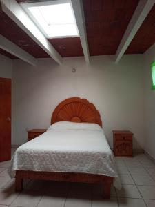 a bedroom with a wooden bed with a skylight at Los Malvones in Tequisquiapan