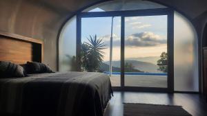 a bedroom with a bed and a large window at Spectacular Igloo-style House in Oaxaca City +23 photos