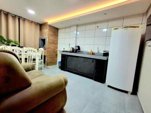 圣罗莎Apartamento novo - 2 Quartos Casal até 4 pessoas - Centro - Santa Rosa - RS的客厅里有一张沙发和一个厨房