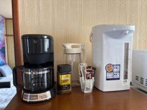 una macchina per il caffè appoggiata su un tavolo accanto a una macchina per il caffè di kitagunihouse noboribetsu a Noboribetsu Altre 24 foto
