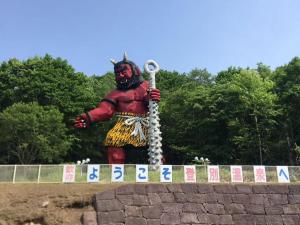 una statua di una persona che indossa una maschera e tiene in mano uno strumento di kitagunihouse noboribetsu a Noboribetsu