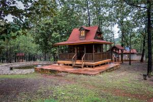 a tree house with a red roof in a park at Cabaña Venado refugio en el bosque para 3 personas in Mascota