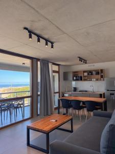 a living room with a couch and a table and a kitchen at Jade Residencias de Mar in Villa Gesell