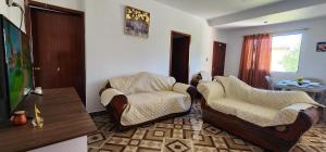 a living room with two chairs and a tv at Departamento en Loja in Loja