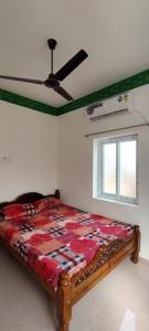 a bed in a room with a ceiling fan at UmaNatarajan Residency in Tiruvannāmalai