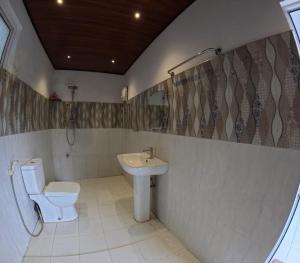 a bathroom with a toilet and a sink at Villa Rivora in Kitulgala