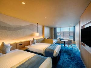 a hotel room with two beds and a flat screen tv at KAMENOI HOTEL Oarai in Oarai