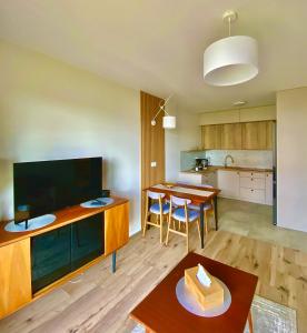 a living room with a large television and a table at Apartament Gruszowe Sady Nowaka 6 in Olsztyn