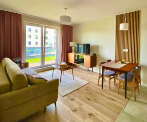 a living room with a couch and a table at Apartament Gruszowe Sady Nowaka 6 in Olsztyn