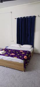 a bedroom with a bed with a blue curtain at Sivahari Homestay in Trivandrum