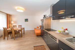 a kitchen with a table and a dining room at Apartments Schmittental - Schmitten62 Self Check-In in Zell am See