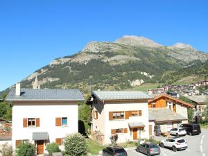 a town in front of a mountain with cars parked at Appartement 4 pers avec balcon et garage à Aussois - FR-1-508B-13 in Aussois +3 photos