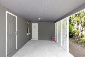 an empty porch with a white door and a window at Modern Coastal Retreat in Fort Myers +5 photos