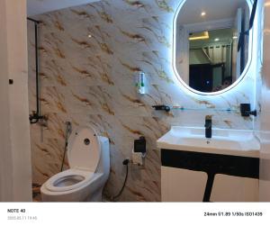 a bathroom with a toilet and a sink and a mirror at Alpine Islamabad in Islamabad