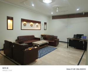 a living room with couches and a table and a screen at Alpine Islamabad in Islamabad