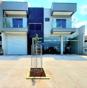 Un pájaro en una jaula frente a un edificio. en Apartamento novo - 2 Quartos Casal até 4 pessoas - Centro - Santa Rosa - RS, en Santa Rosa
