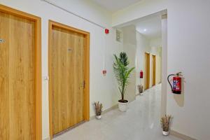 古尔冈Hotel O Star key的走廊上设有木门和盆栽植物