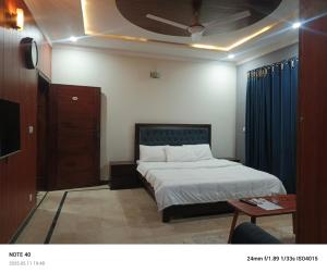 a bedroom with a bed and a ceiling at The Guest House Islamabad in Islamabad