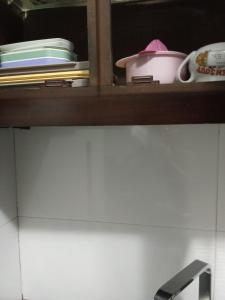 a shelf in a kitchen with dishes and a sink at Glenfalls Residencies in Nuwara Eliya