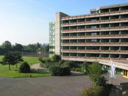 a large building with a parking lot in front of it at Overnight Tagungshotel im ABZ in Kerpen