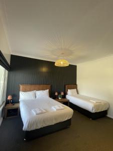 a hotel room with two beds and a chandelier at Palm and Pawn Motor Inn in Wagga Wagga