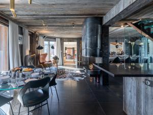 a living room with a table and chairs and a fireplace at Chalet haut de gamme proche des pistes avec sauna et parking privé - FR-1-344-1209 in Saint-Martin-de-Belleville