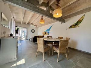 a kitchen and dining room with a table and chairs at Maison à Saint Denis d'Oléron - Jardin - 6 personnes - FR-1-246A-372 in Saint-Denis-dʼOléron