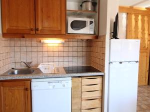 a kitchen with a white refrigerator and a sink at Appartement calme proche navettes à Aussois - FR-1-508B-25 in Aussois