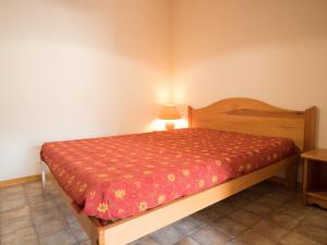 a bedroom with a bed with a red comforter at Appartement calme proche navettes à Aussois - FR-1-508B-25 in Aussois