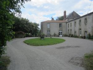 an old house with a driveway in front of it at Le Manoir "Aux Douves" in Bazoges-en-Paillers
